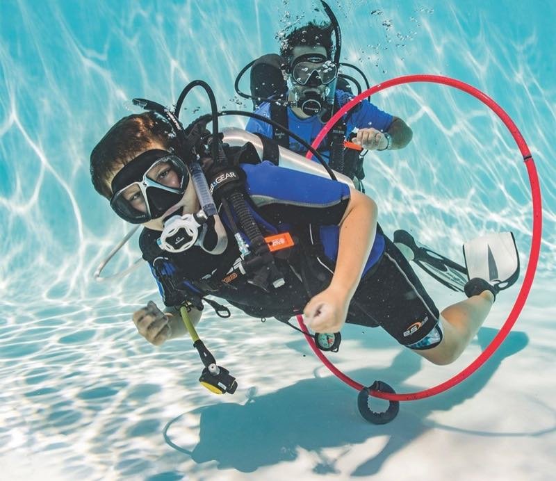 A first-time diver breathing underwater in the pool
