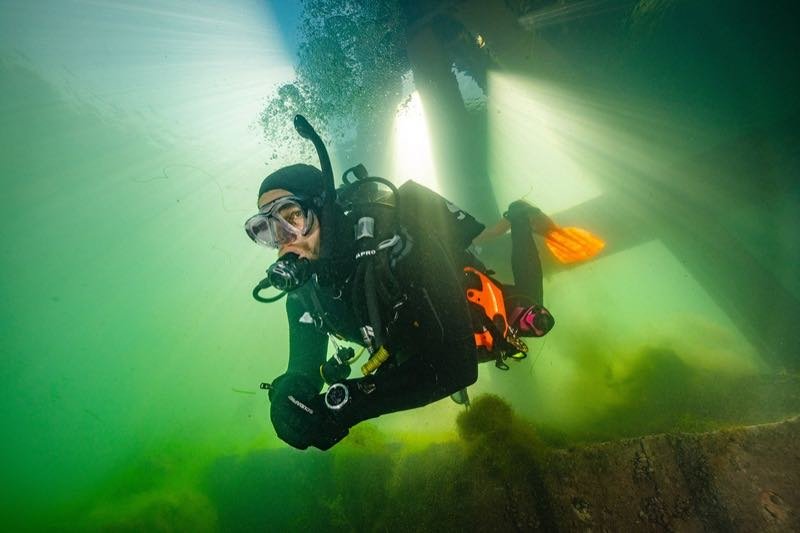A drysuit diver preparing to enter the water