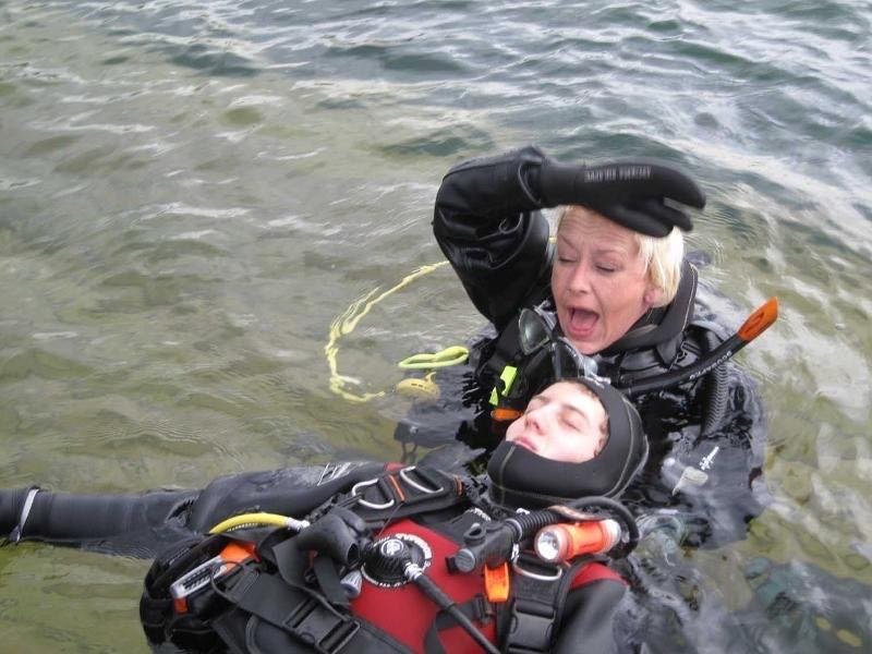 A diver signalling for assistance at the surface during rescue training