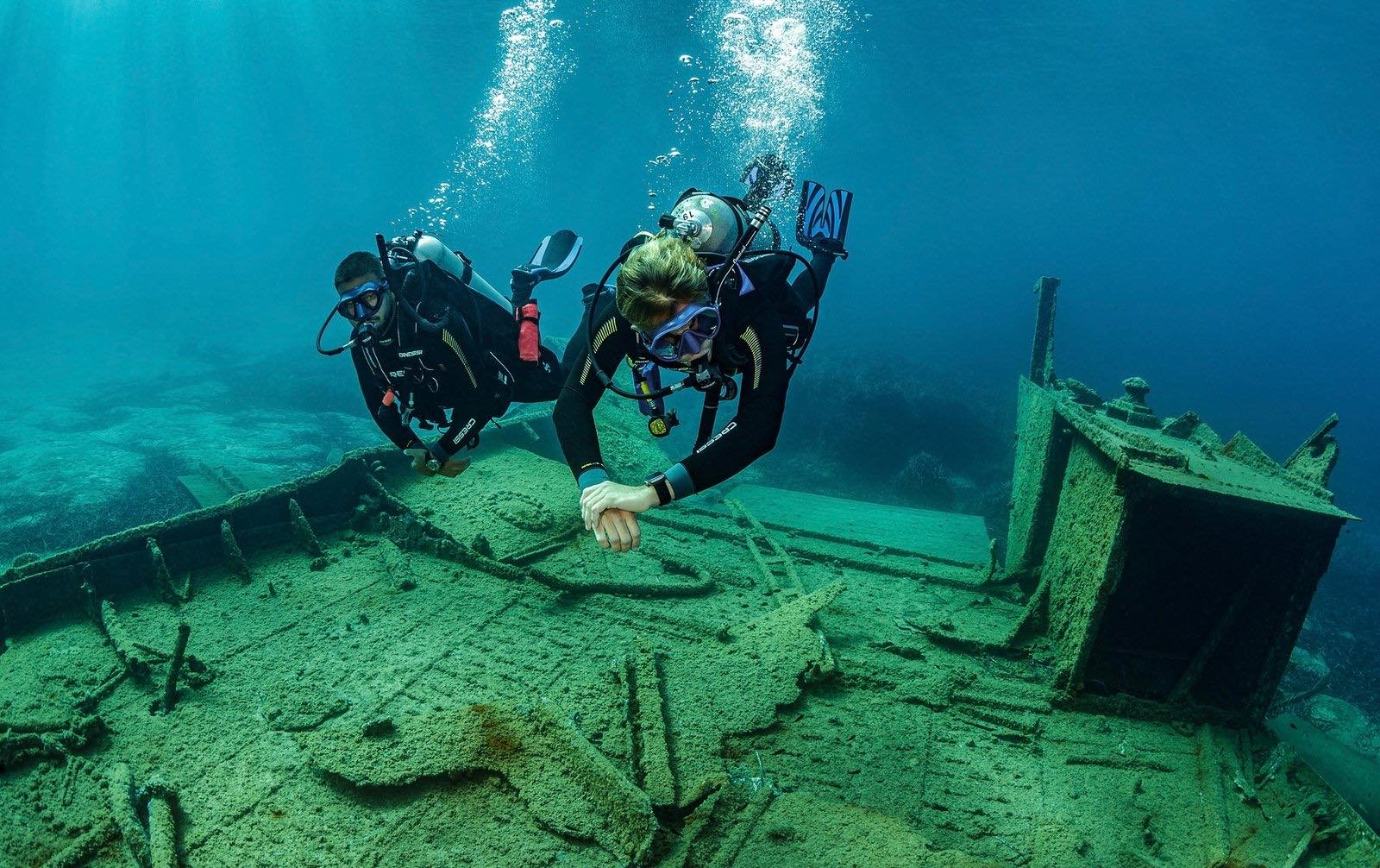 A diver exploring a wreck in clear water